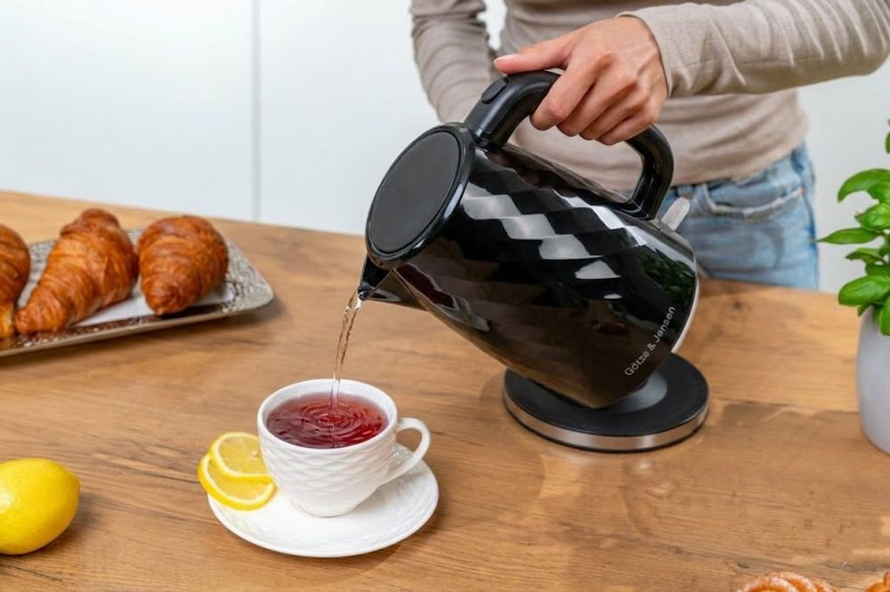 GÖTZE & JENSEN KT101W - czajnik trzymany w ręce, obok talerzyki z przekąskami