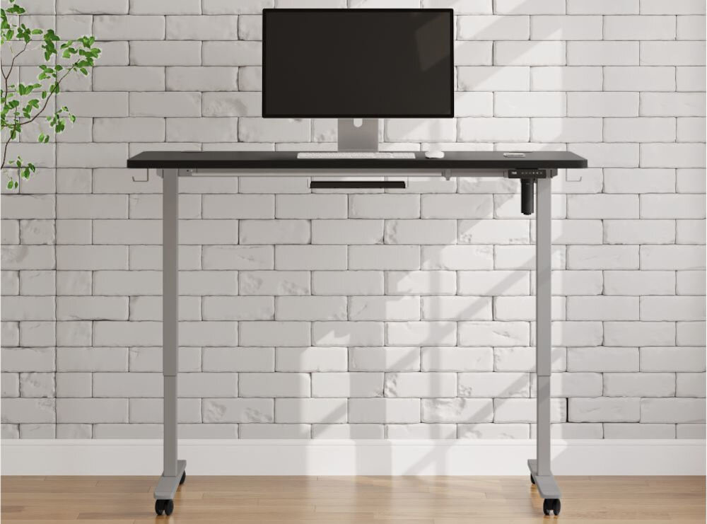 Biurko KENOKO Ibuki 160 x 80 cm Czarno-szary prezentacja biurka w pokoju na jasnej ceglanej ścianie na biurku monitor system Finger Protect Child Protect bezpieczeństwo ochrona przed przypadkowym przycięciem palców ograniczenie ryzyka kolizji wydłużenie żywotności