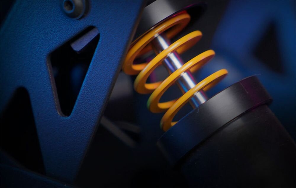 Pedał sprzęgła MOZA Racing SR-P RS111 Detale górnej części amortyzatora z żółtą sprężyną osadzoną na stalowym trzpieniu, zamontowaną w czarnej ramie pedału 16-bitowy enkoder magnetyczny algorytm synchronizacji dwóch czujników wysoka dokładność i czułość regulacja krzywej wyjściowej