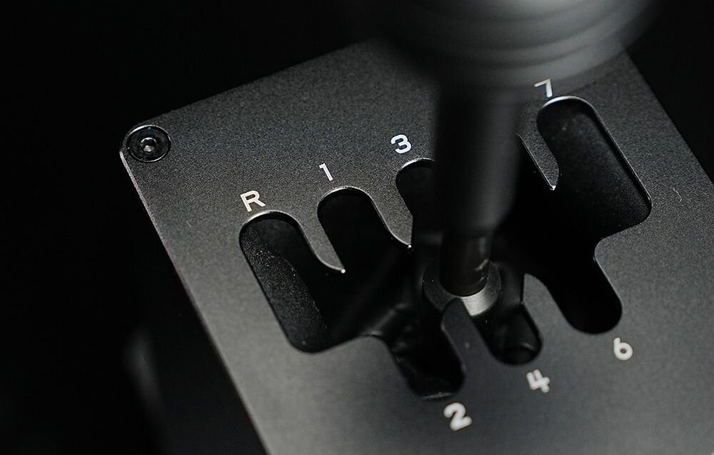 Skrzynia biegów MOZA Racing HGP RS039 Zbliżenie na stalową bramkę zmiany biegów z grawerowanymi numerami od R do 7 w symulatorze MOZA 7 biegów oraz wsteczny mechaniczna blokada zapobieganie przypadkowej zmianie biegów