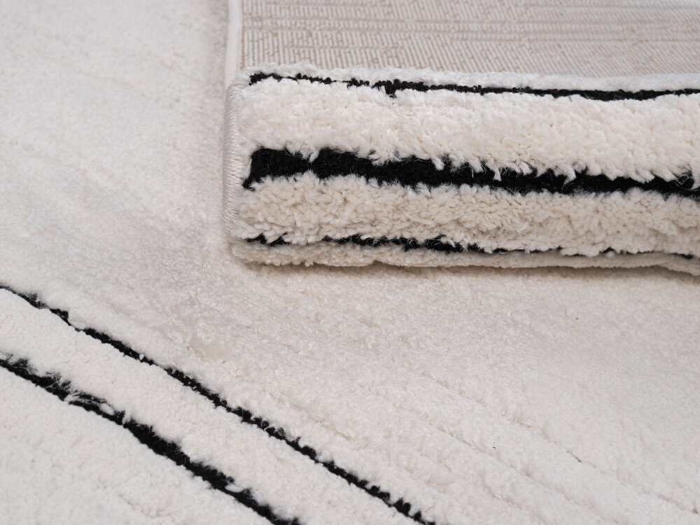 Dywan wewnętrzny MULTIDECOR Elio Linie 508386 200 x 290 cm Kremowo-czarny, 3D, grubość, faktura, gramatura, zbliżenie na dywan, obok zrolowany dywan na nim