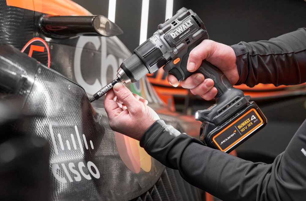 Wiertarko-wkrętarka DEWALT DCD85MM1T-QW osoba używa narzędzia trzyma bit w dłoni wbudowany system antywibracyjny zmniejsza odczuwalne drgania komfort pracy redukuje ryzyko kontuzji funkcja rewersu szybkozaciskowy uchwyt o zakresie 1,5-13 mm