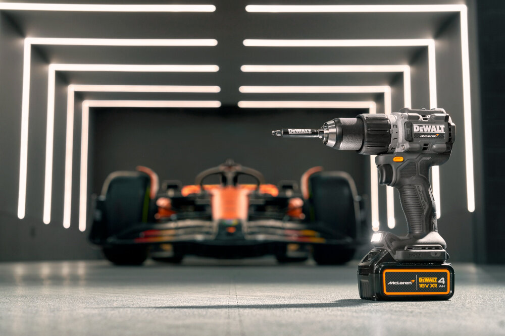 Wiertarko-wkrętarka DEWALT DCD85MM2T-QW garaż urządzenie stoi na podłodze w tle samochód McLaren duża moc wszechstronność kontrola bezpieczeństwo