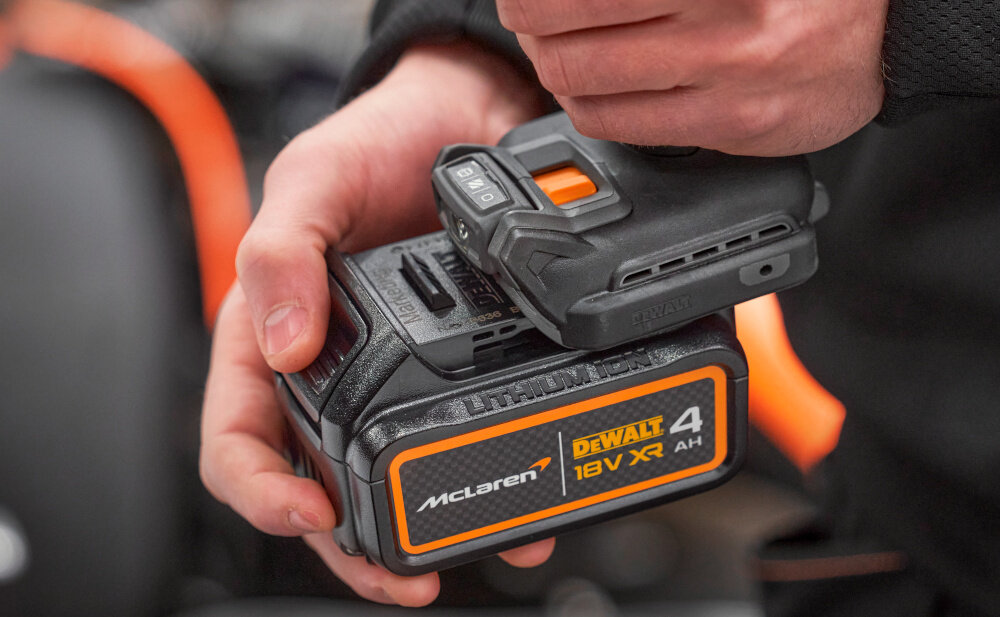 Wiertarko-wkrętarka DEWALT DCD85MM2T-QW zbliżenie na akumulator osoba wsuwa akumulator w urządzenie akumulator Li-Ion z serii 18 V XR o pojemności 4 Ah system zasilania bezprzewodowego swoboda ruchu