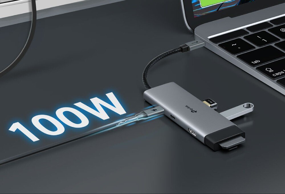 Hub TP-LINK UH7020C Adapter podłączony do laptopa, do którego wpięty jest kabel zasilający USB typu C z symbolem pioruna, obok którego widnieje duży napis '100W'