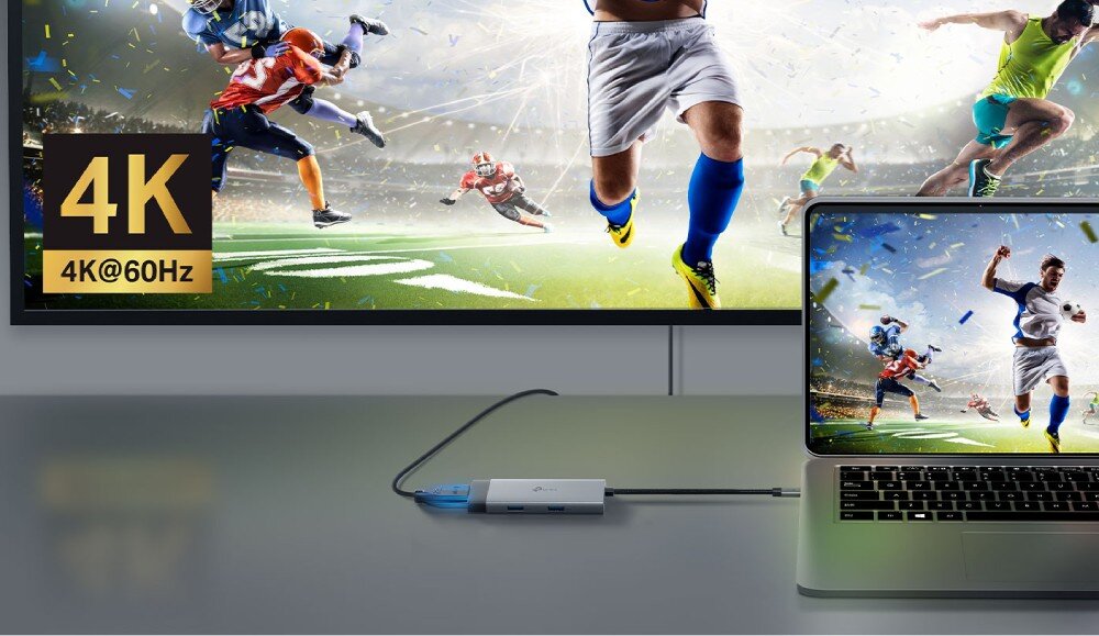Hub TP-LINK UH5020C Laptop i monitor zewnętrzny wyświetlający mecz futbolu amerykańskiego, połączone adapterem z wpiętym kablem wideo, obok widoczny logotyp '4K@60Hz'