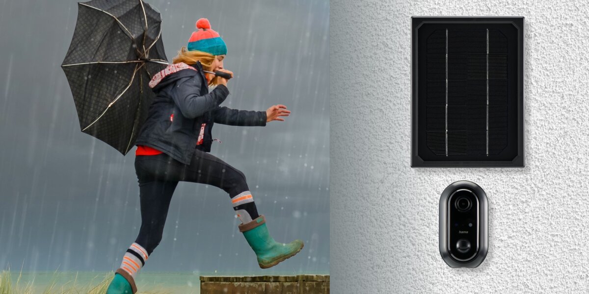 Kamera HAMA 176648 zewnętrzna Wi-Fi + Panel solarny Czarny, deszcz, kurz, montaż, elewacja, Osoba skacze w deszczu na podest, obok na białym tle kamera i panel