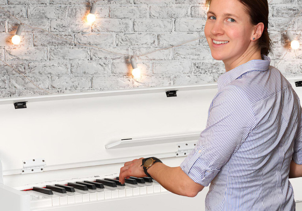 V-TONE DP-88 WH przenośne pianino cyfrowe z wbudowanymi głośnikami i statywem, osoba siedząca przy pianinie w pomieszczeniu