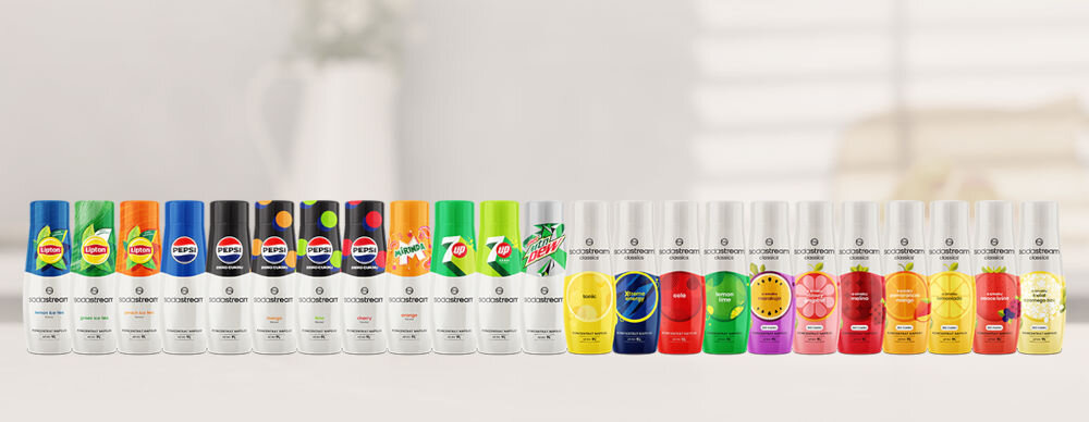 Syrop do saturatorów SODASTREAM Tonic 440 ml jasne tło szereg kolorowych butelek z syropami Pepsi Pepsi Cherry Mirinda 7UP Lipton Ice Tea kultowe smaki orzeźwienie Cola Cytryna Limonka Xtreme Energy smak charakter Malina Marakuja Pomarańcza Mango Owoce Leśne bez dodatku cukru Crafted koktajle moktajle nietypowe kompozycje tworzenie eksperymentowanie mieszanie 