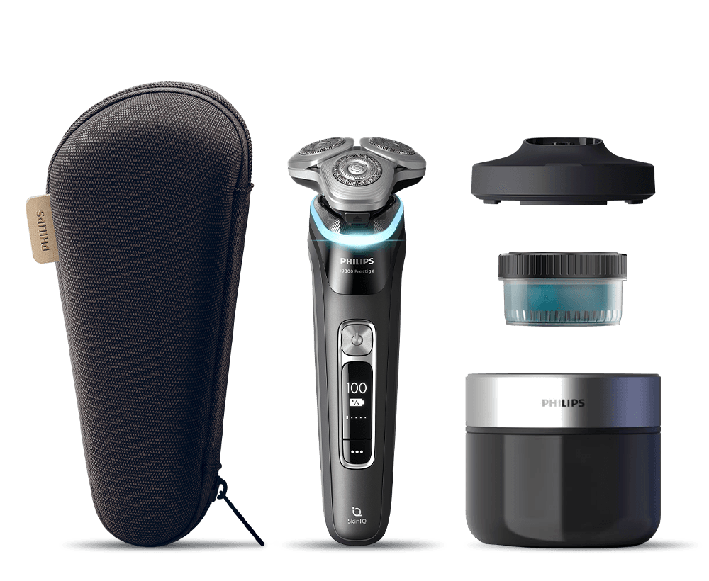 Golarka z akcesoriami - etui, trymerem do brody, podstawką ładującą, stacją czyszczącą i wkładem. Golarka z akcesoriami - etui, trymerem do brody, stacją czyszczącą i wkładem. Golarka leżąca w otwartym etui. Golarka z głowicą umieszczoną w stacji czyszczącej. Golarka umieszczona w stacji ładującej. Okrągły przezroczysty pojemnik z czarną nakrętk z niebieskim płynem w  środku.