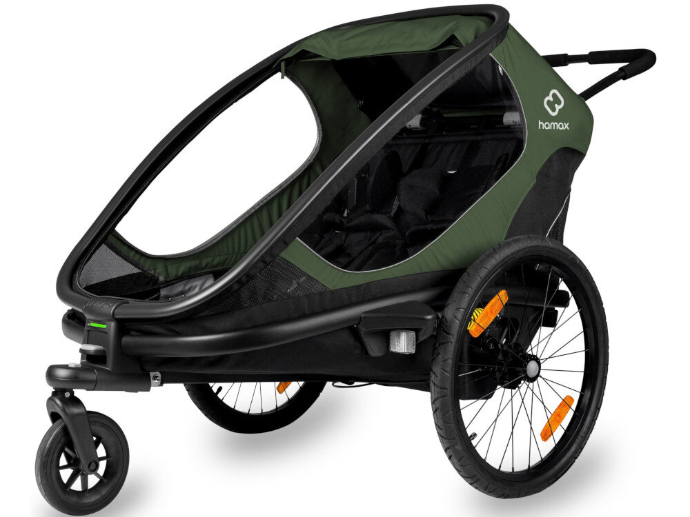 Przyczepka rowerowa w kolorze zielono-czarnym z trzema kołami i logo \'hamax\' na boku. Posiada przezroczystą osłonę z przodu i pomarańczowe odblaski na kołach.