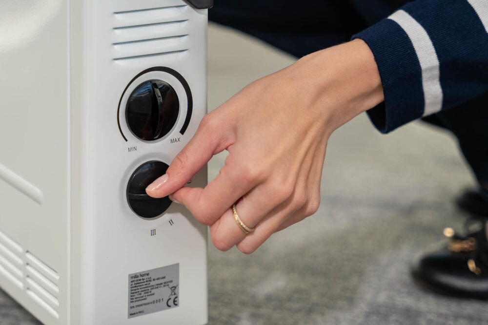 Grzejnik konwektorowy MILLA HOME MCH103 zmiana stopnia grzania osoba modyfikująca grzanie za pomocą pokrętła