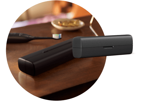 Na blacie leży etui, a za nim szczoteczka. Obok znajduje się etui podróżne.