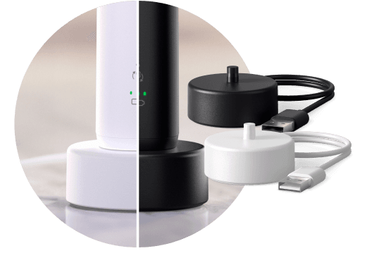 Szczoteczka umieszczona w podstawce ładującej. Obok znajdują się dwie podstawki ładujące  – biała i czarna.