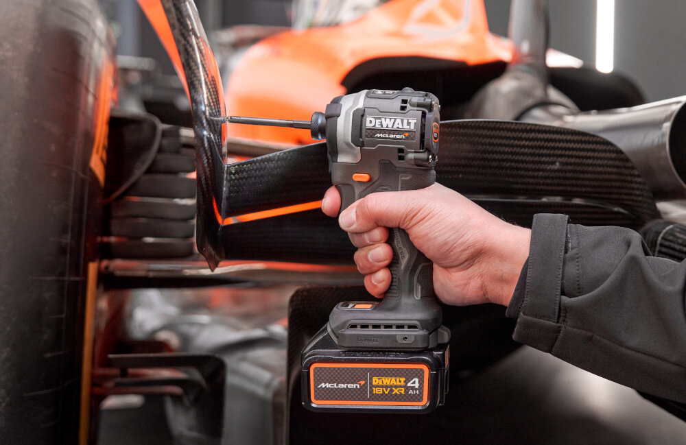 Zakrętarka udarowa DEWALT DCF85MM2T-QW osoba trzyma urządzenie w dłoni narzędzie w pionie akumulator litowo-jonowy o napięciu 18 V i pojemności 4 Ah bezprzewodowe zasilanie pełna mobilność duża swoboda ruchu łatwy dostęp do trudno dostępnych miejsc w zestawie dwa akumulatory ładowarka