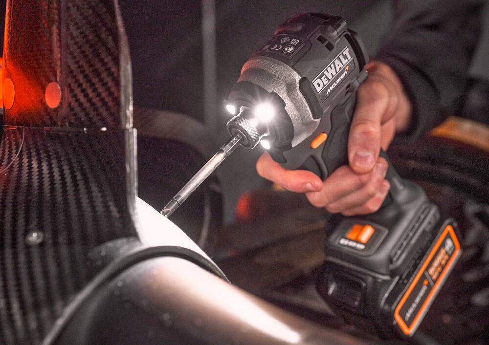 Zakrętarka udarowa DEWALT DCF85MM2T-QW ciemne pomieszczenie osoba trzyma narzędzie w dłoni widoczne diody LED świecą się zintegrowana 3-stopniowa dioda LED z funkcją obracania doświetla pole pracy regulacja natężenia światła bezpieczeństwo
