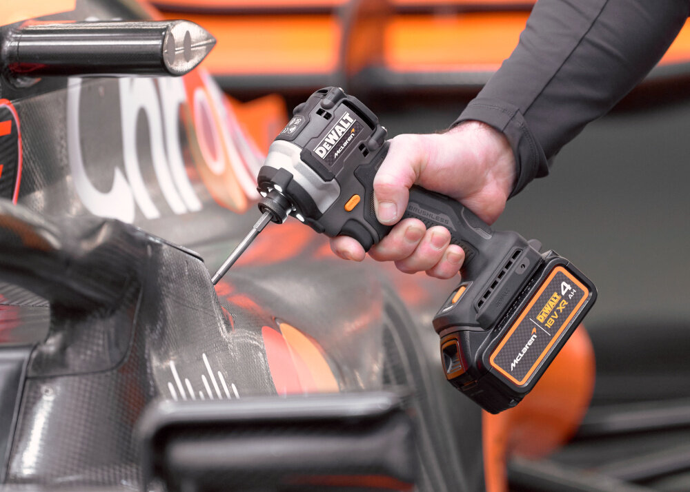 Zakrętarka udarowa DEWALT DCF85MM1T-QW osoba trzyma urządzenie w dłoni narzędzie pod skosem funkcja udaru generuje do 3800 uderzeń na minutę tryb udaru skuteczne działanie w twardych materiałach i przy trudnych połączeniach śrubowych