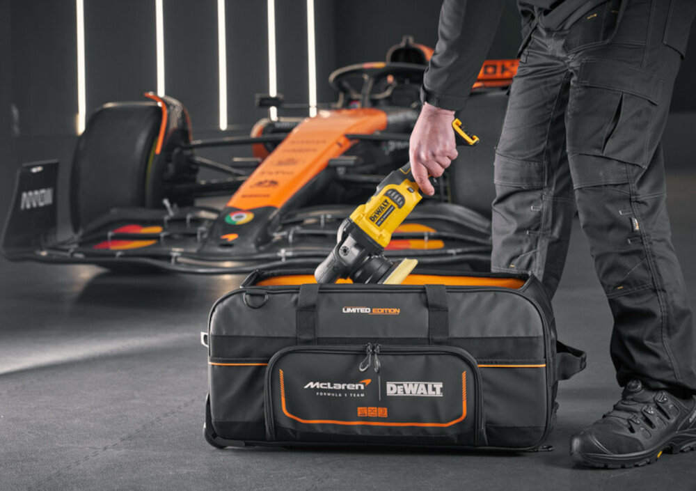 Torba narzędziowa DEWALT DWST83522-9 torba na podłodze widoczna od przodu osoba wkłada do niej elektronarzędzie porządek wygoda w pracy funkcjonalność organizacja mobilność