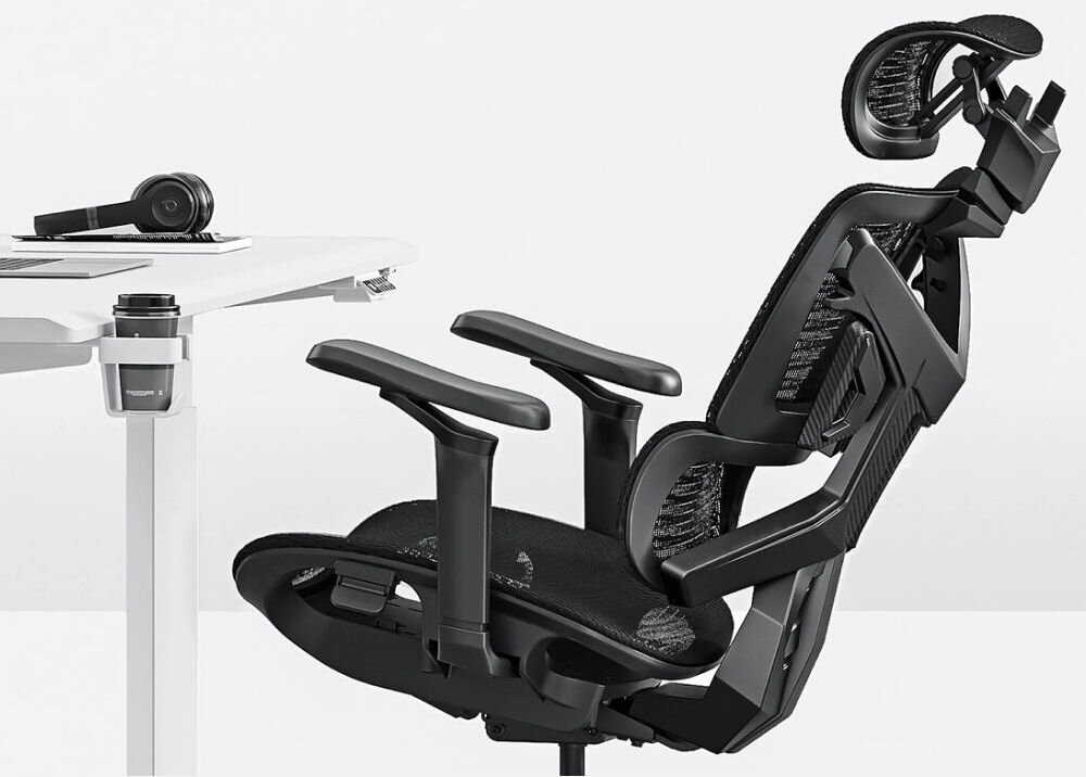 Fotel ANDA SEAT X-Air Pro XL Czarny prezentacja możliwego kąta oparcia fotela znajdującego się przy białym biurku na biurku znajduje się laptop słuchawki notatnik i kawa w uchwycie mechanizm swobodnego nachylenia ustawienie kąta od 105° do 126° szersze w części ramion stabilne wsparcie ciała skupienie na pracy wygoda