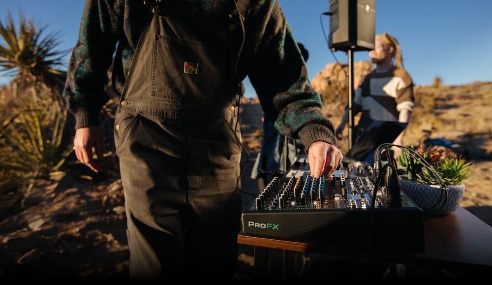 Mikser audio MACKIE ProFX10 GO mobilne miksowanie analogowe interfejs USB-C praca w terenie, mikser stojący na stole, osoba stojąca przy mikserze