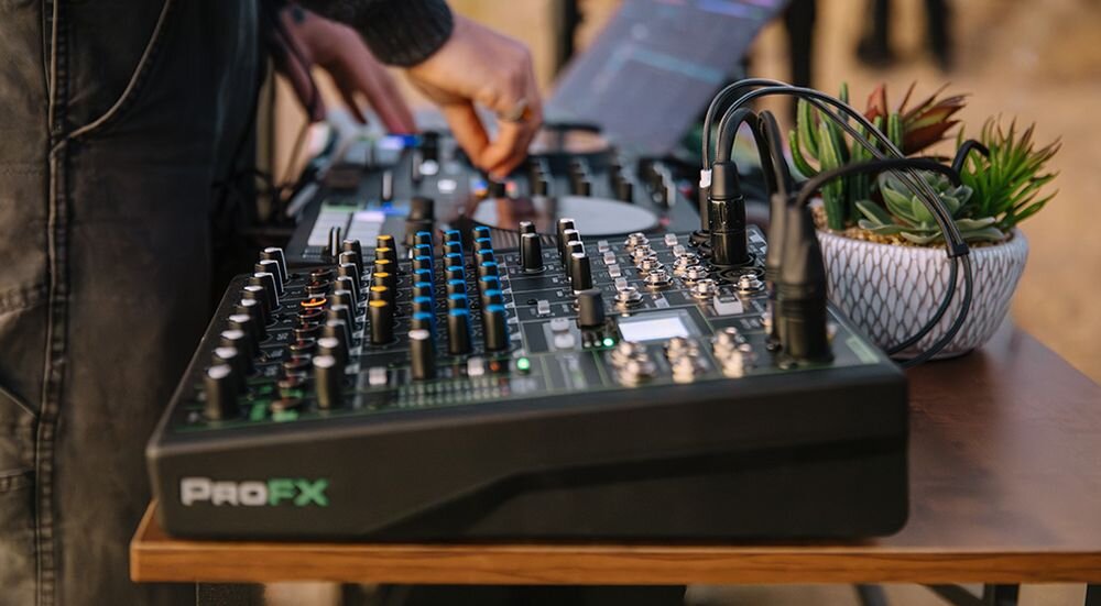 Mikser audio MACKIE ProFX10 GO przedwzmacniacze Onyx 60 dB phantom 48V, mikser stojący na stole, osoba stojąca przy mikserze