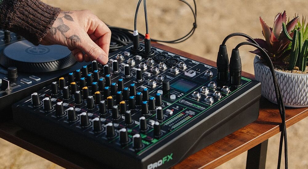 Mikser audio MACKIE ProFX10 GO korekcja EQ kompresja kontrola dynamiki, mikser stojący na stole, osoba stojąca przy mikserze