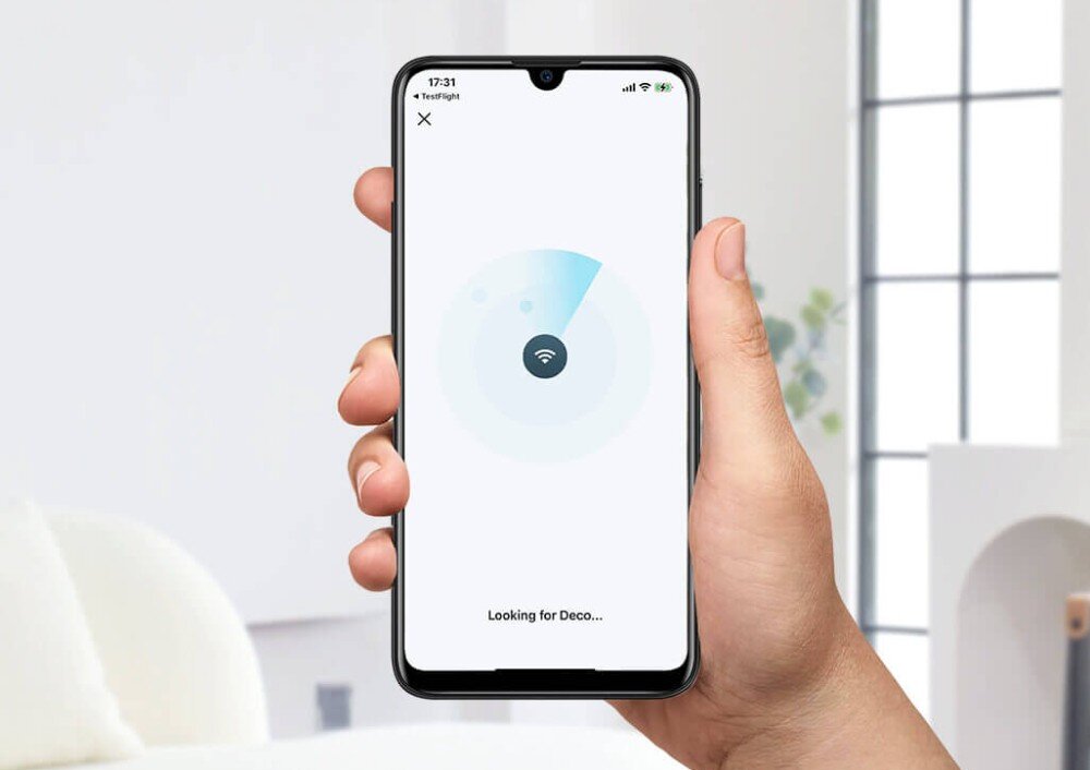 Router TP-LINK Deco X50 Pro Dłoń trzymająca smartfon z włączoną aplikacją pokazującą wyszukiwanie sygnału Wi-Fi, aplikacja, narzędzia, kontrola