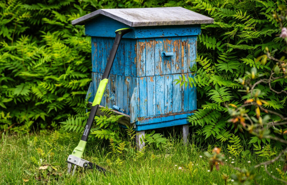 Wyrywacz do chwastów STALCO GARDEN EXP S105210372 ogród niebiski ul wyrywacz oparty o ul w tle rośliny do szybkiego i wygodnego usuwania niechcianych roślin wraz z korzeniem pozwala pozbyć się chwastów bez konieczności schylania się i bez brudzenia rąk