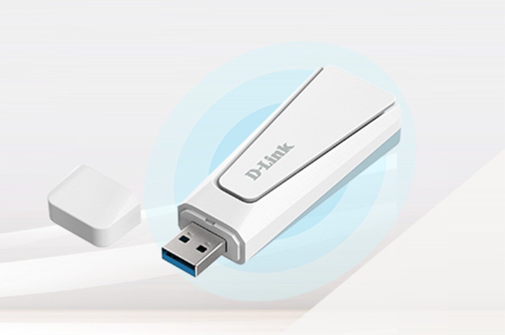 Karta sieciowa D-LINK AX18U Zbliżenie na białą kartę sieciową USB z napisem „D-Link”, obok leży jej zdjęta zatyczka. W tle widoczne są koncentryczne kręgi symbolizujące sygnał, standard Wi-Fi 6, prędkość