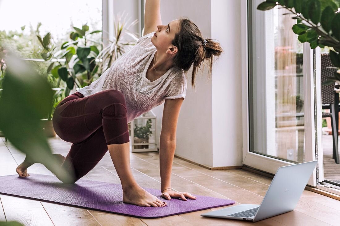 Kobieta wykonuje jogę przed laptopem DELL 16 Plus, skupiona na ćwiczeniach i relaksie.  - procesor Intel Core Ultra, pamięć RAM, Dysk SSD  