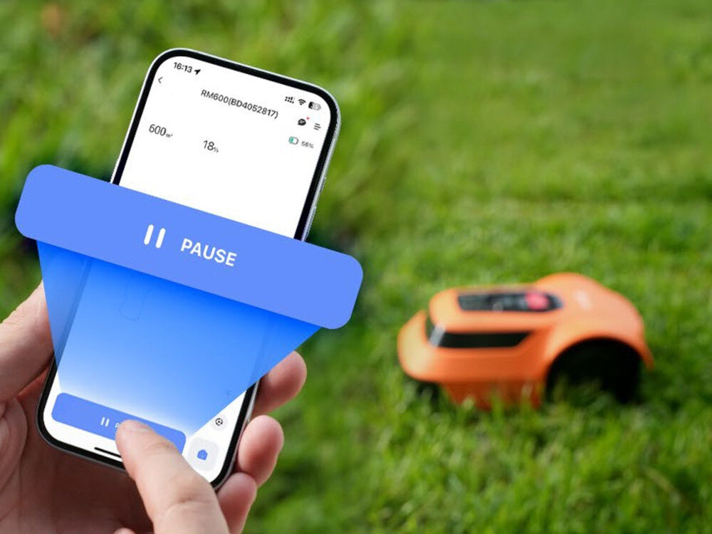 Robot koszący EZVIZ RM600 CS-R64-A11 sterowanie Bluetooth-Wi-Fi osoba trzyma telefon z włączoną aplikacją w tle robot na trawie zdalna kontrola aplikacja EZVIZ łączność Wi-Fi/Bluetooth na systemy Android i iOS