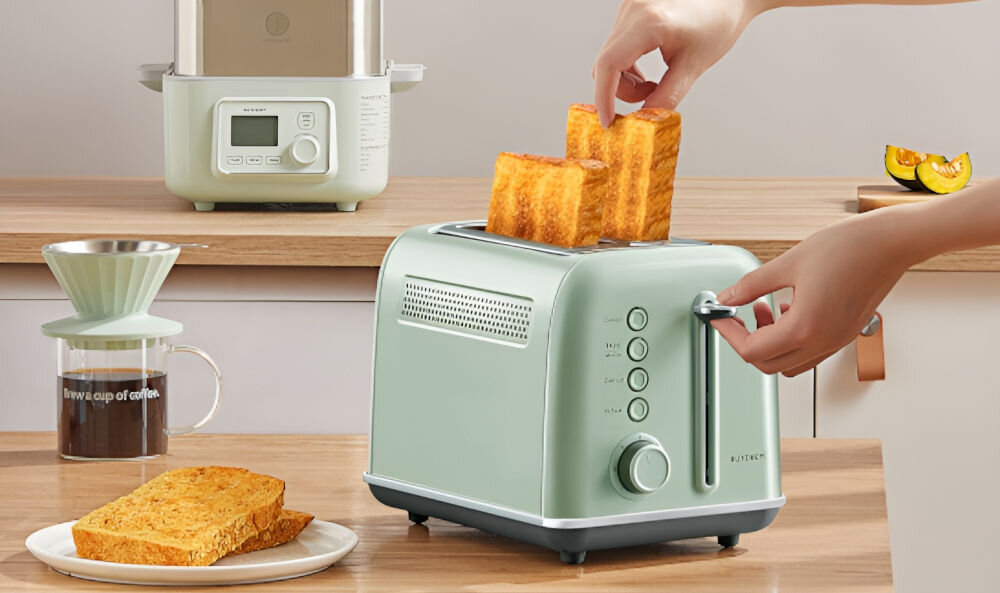 TOSTER BUYDEEM DT620E MIĘTOWY toster w kolorze miętowym stojący na blacie osoba trzyma dźwignię i wyciąga upieczone grzanki ze środka 7 poziomów opiekania 5 podstawowych funkcji sterowanie przyciskami funkcja rozmrażania pieczywa przygotowywanie ulubionych przekąsek lekko przyrumienione mocno przypieczone pieczywo