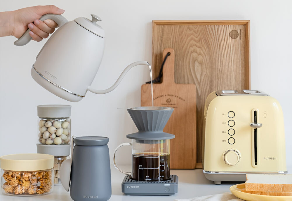 Czajnik BUYDEEM K821 Biały czajnik w białym kolorze osoba trzyma czajnik za rączkę i wlewa wodę do karafki chroni przed oparzeniem szczelna pokrywka chropowata rączka wąska szyjka do nalewania wody automatyczne wyłaczenie gdy jest pusty zwiększone bezpieczeństwo szczelna pokrywka zapobieganie rozlewaniu wody chropowata rączka pewny chwyt wąska szyjka precyzyjne nalewanie bezpieczeństwo wygoda praktyczny codzienne użytkowanie 