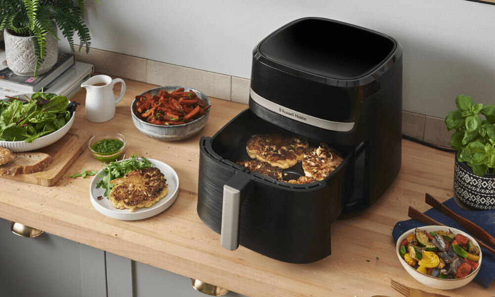 Air Fryer Frytkownica beztłuszczowa RUSSELL HOBBS Satisfry 27630-56 połowa piekarnik połowa zdjęcie frytkownicy białe tło zużywa ponad połowę mniej energii oszczędność na rachunkach za prąd ekologiczne przygotowywanie posiłków dbanie o środowisko oszczędności domowe