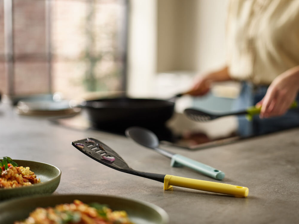Zestaw przyborów kuchennych JOSEPH JOSEPH Opal Duo (3 elementy) leżące na blacie w tle gotująca osoba nylon tworzywo sztuczne odporność na temperatury do 200 stopni podpórki obciążniki w uchwytach