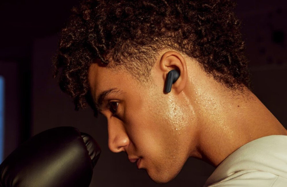Słuchawki OPPO Enco Buds3 Pro odporność IP55 pył pot deszcz trening, osoba z załozonymi słuchawkami dokanałowymi uprawiająca boks