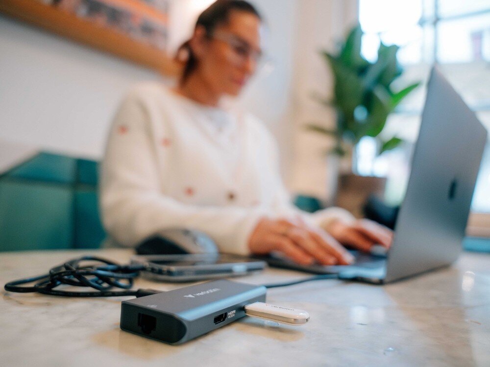 Hub Verbatim 32157 Osoba pracuje przy laptopie w jasnym pomieszczeniu. Na pierwszym planie widoczny hub USB-C z kilkoma podłączonymi urządzeniami, w tym pendrive’em,
hub design kompaktowy lekki konstrukcja trwałość