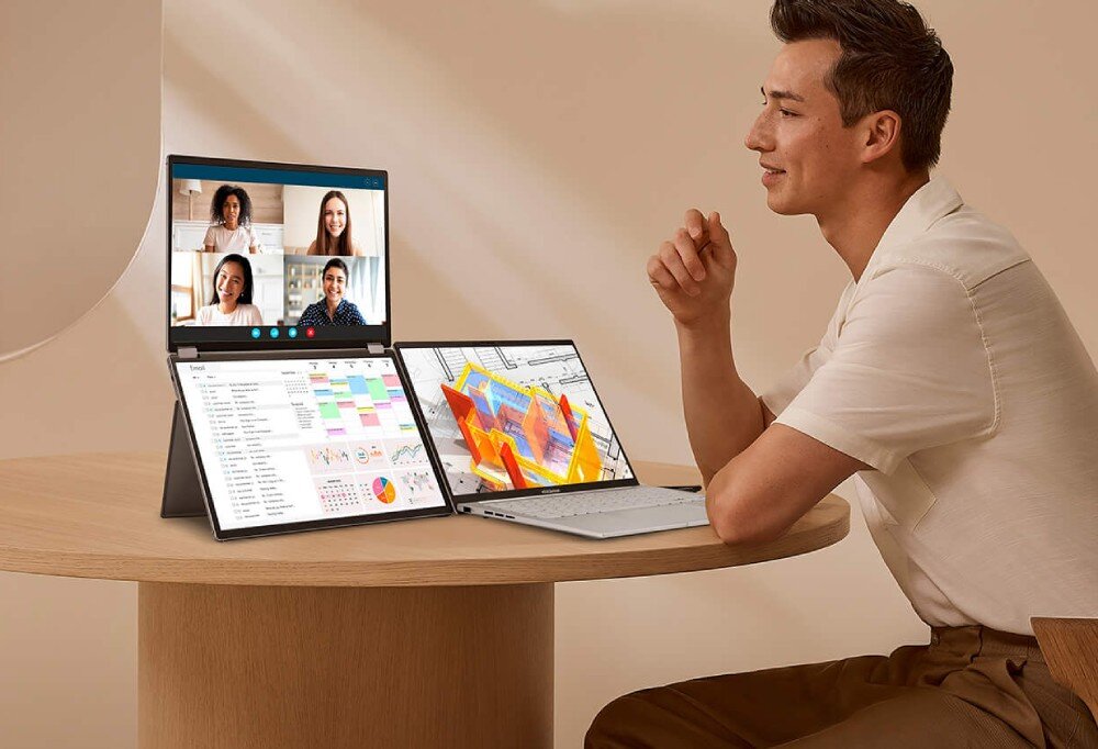 Monitor ASUS ZenScreen Duo MQ149CD Mężczyzna siedzi przy okrągłym stole, przed nim laptop i monitor z dwoma ekranami, na górnym ekranie wideokonferencja, na dolnym widok kalendarza i wykresów, opis