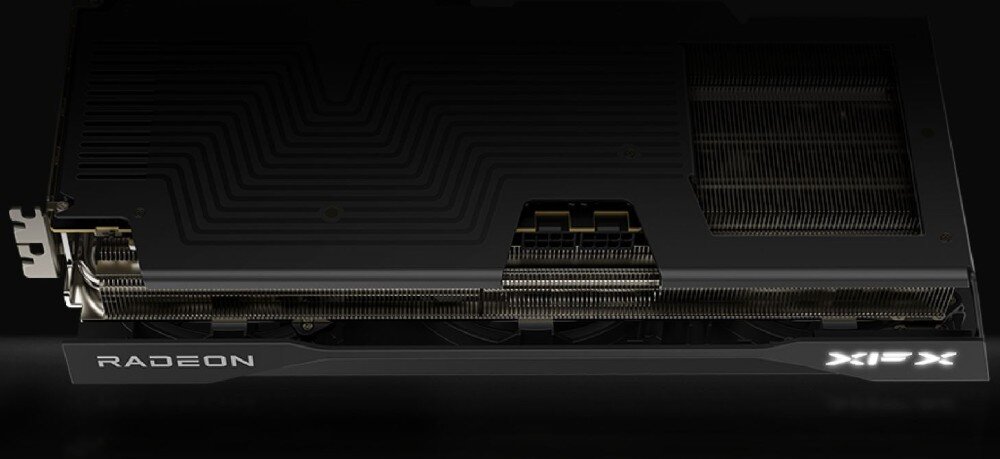 Karta graficzna XFX Swift Radeon RX 9070 OC Triple Fan Gaming Edition Widok boczny karty graficznej. Pokazana jest dolna część obudowy z otworami wentylacyjnymi, złączem zasilania i podświetlanymi napisami 'RADEON' oraz 'XFX', architektura, procesory strumieniowe, taktowanie