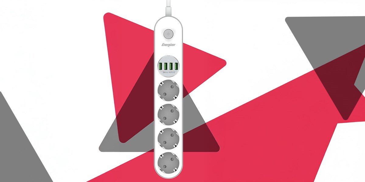 Listwa ENERGIZER EPB2500W00EU (2 m) biały Pionowe ujęcie listwy zasilającej Energizer na nowoczesnym, geometrycznym tle w kolorach czerwonym, białym i czarnym. Widoczne są trzy gniazda typu F, pięć portów USB i przycisk włącznika