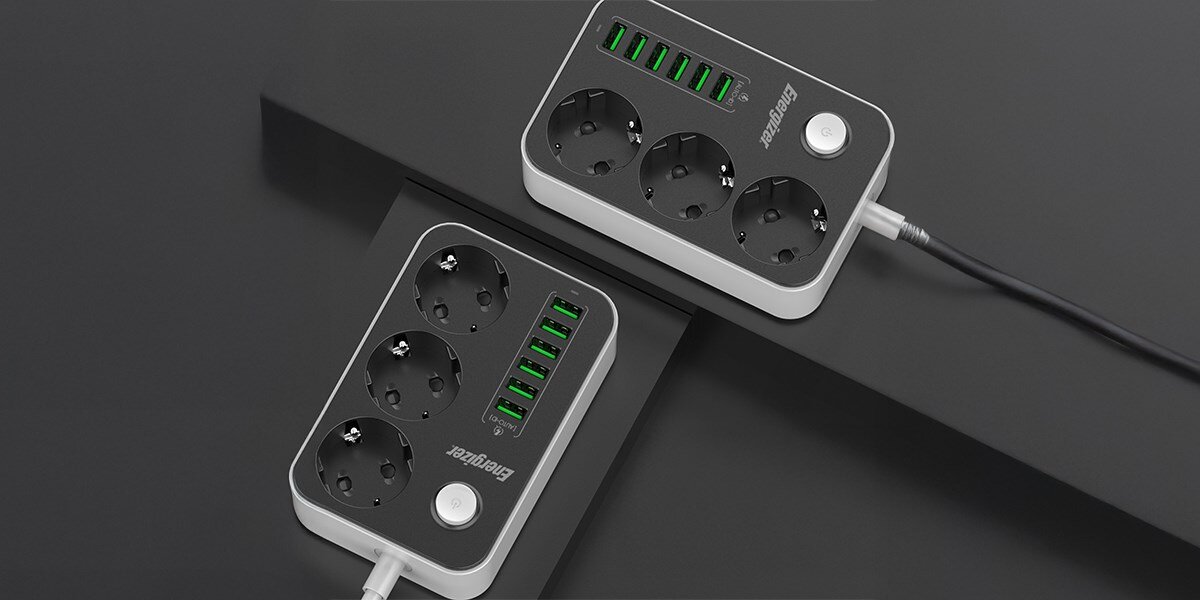 Listwa ENERGIZER EPB2500W01EU (2 m) Czarno-biały Dwie listwy zasilające Energizer z trzema gniazdami i pięcioma portami USB ułożone skośnie na ciemnym, matowym tle. Zdjęcie ma na celu pokazanie dwóch urządzeń jednocześnie lub różnych perspektyw