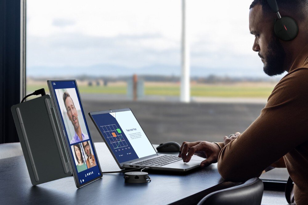 Monitor DELL Pro 14 Plus P1425 Mężczyzna w słuchawkach pracujący przy laptopie z dodatkowym monitorem ustawionym pionowo, na którym widać wideokonferencję i prezentację, wykorzystanie, cechy, zalety