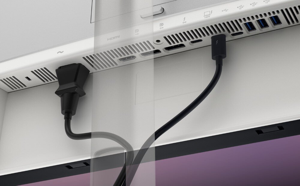 Monitor DELL UltraSharp U2725QE Zbliżenie na tylny panel złączy monitora z podłączonym czarnym kablem zasilającym po lewej i kablem Thunderbolt po prawej stronie, widoczne liczne otwory wentylacyjne i inne porty, zasilanie, złącze Ethernet, kompatybilność