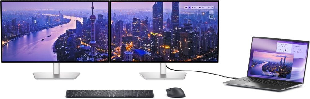Monitor DELL UltraSharp U2725QE Zestaw dwóch identycznych monitorów ustawionych obok siebie na białym tle, oba wyświetlają tę samą panoramę miasta, połączone kablem z otwartym laptopem po prawej, na pierwszym planie klawiatura i mysz, współpraca z macOS, aplikacja, konfiguracja