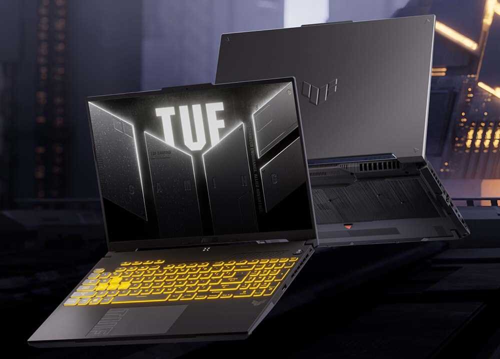 ASUS TUF Gaming F16 baner z dwoma laptopami w nocnym środowisku miejskim z logo TUF i podświetloną klawiaturą, pokazujący flagowy laptop gamingowy z ekranem 16 cali 165Hz i militarną wytrzymałością MIL-STD-810H dla profesjonalnych graczy