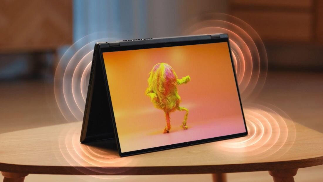 Laptop ASUS VivoBook z Dolby Atmos w trybie namiotu stoi na stole, emitując fale dźwięku podczas oglądania multimediów 