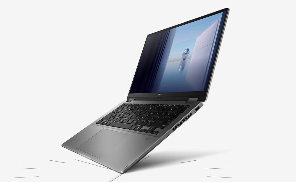 Laptop w kolorze srebrnym z widocznym ekranem wyświetlającym abstrakcyjny obraz. Klawiatura jest czarna, a obudowa ma nowoczesny design.