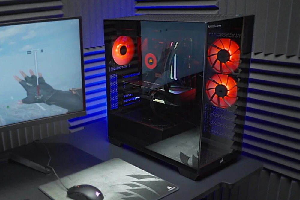 Komputer OPTIMUS E-sport GA550T-CR4 Zbliżenie na zestaw komputerowy podczas gry – obudowa z trzema czerwonymi wentylatorami LED, przezroczysty panel boczny, a obok monitor z widokiem z gry, karta graficzna, technologia, grafika