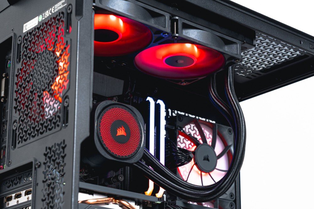 Komputer OPTIMUS E-sport GA550T-CR4 Ujęcie z dołu komputera ukazujące chłodnicę wodnego chłodzenia zamontowaną na górze obudowy, wentylatory z czerwonym podświetleniem i przewody chłodzenia, chłodzenie procesora