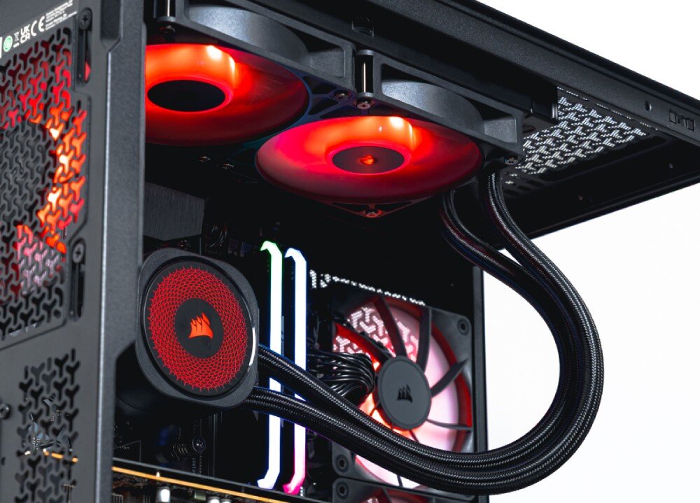 Komputer OPTIMUS E-sport GA550T-CR5 Ujęcie z dołu komputera ukazujące chłodnicę wodnego chłodzenia zamontowaną na górze obudowy, wentylatory z czerwonym podświetleniem i przewody chłodzenia, chłodzenie procesora